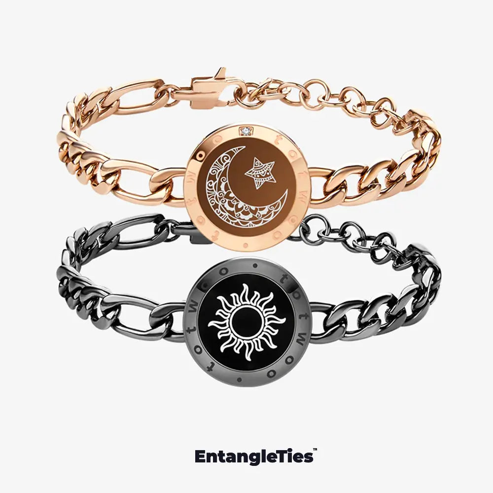 Two EntangleTies™ bracelets — one with a crescent moon and star design in gold, and the other with a sun design in black, both with Figaro Chain links, displayed on a white background with the EntangleTies™ logo at the bottom.