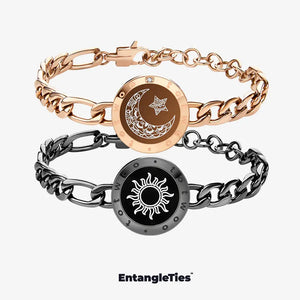 Two EntangleTies™ bracelets — one with a crescent moon and star design in gold, and the other with a sun design in black, both with Figaro Chain links, displayed on a white background with the EntangleTies™ logo at the bottom.