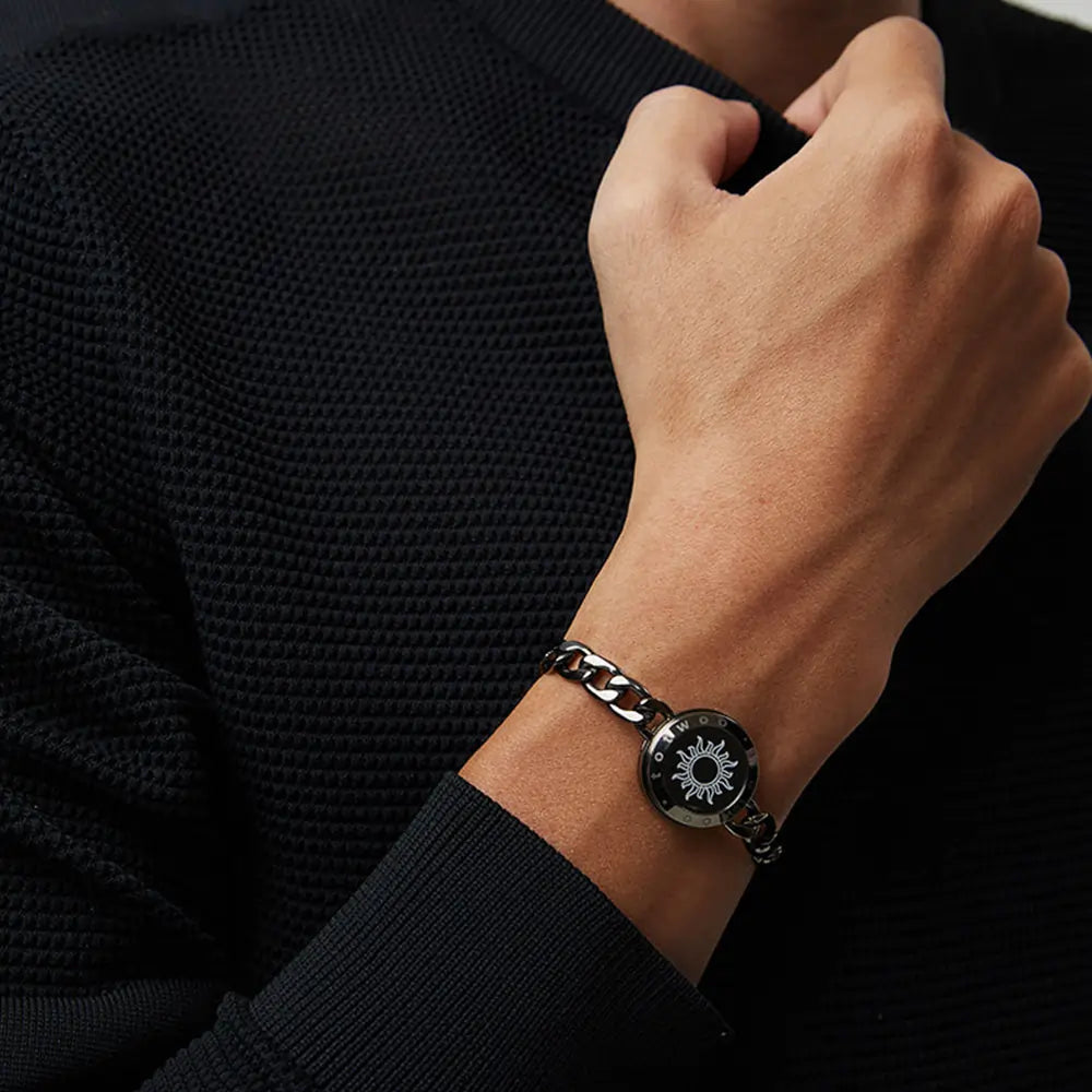 A man wearing the EntangleTies™ Sun bracelet, featuring a sleek black outfit and chain link design.