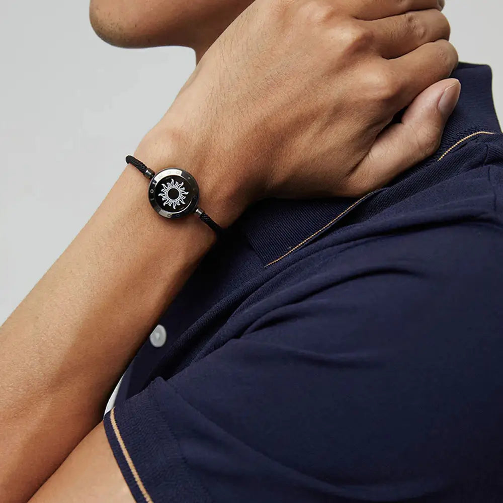 A man wearing the EntangleTies™ Sun bracelet with a sleek rope cord design, hand near his face, against a minimalistic background.